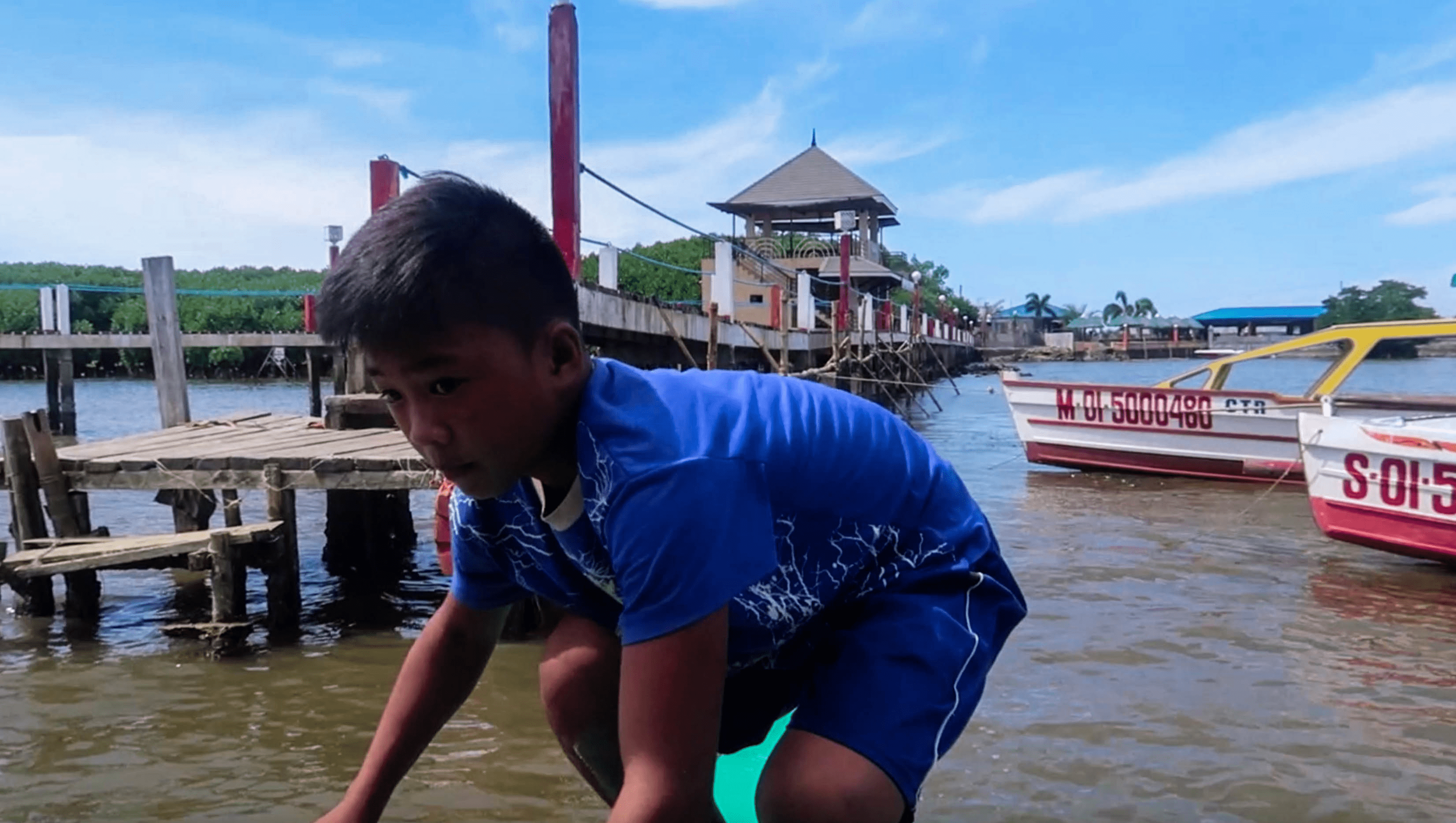 filipino boat boy docking off boat at hundred islands alternate welcome center mangrove park in pangasinan philippines